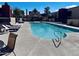 Community pool with lounge chairs, landscaping, and a clubhouse in the background at 1340 N Recker Rd # 219, Mesa, AZ 85205