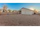 Open backyard with gravel, block wall, and covered patio, providing a simple and private outdoor space at 13913 N 133Rd Dr, Surprise, AZ 85379