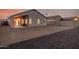 Spacious backyard with gravel, block wall, and covered patio at dusk at 13913 N 133Rd Dr, Surprise, AZ 85379