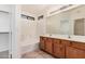 Bathroom featuring dual sinks, tiled floor, large mirror, and shower-tub combo at 13913 N 133Rd Dr, Surprise, AZ 85379