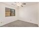 Bedroom with carpeted floor, ceiling fan, and large window, creating a comfortable space at 13913 N 133Rd Dr, Surprise, AZ 85379