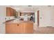 Well-lit kitchen featuring wooden cabinetry, ample counter space, and white appliances at 13913 N 133Rd Dr, Surprise, AZ 85379