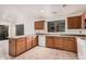 The kitchen features light wooden cabinets, white appliances, tile flooring, and plenty of counter space at 13913 N 133Rd Dr, Surprise, AZ 85379