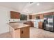 A kitchen with wooden cabinetry, tile floors, a breakfast bar, and white appliances at 13913 N 133Rd Dr, Surprise, AZ 85379