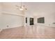 Bright living room with tile flooring, a ceiling fan, and large windows with a view to the back at 13913 N 133Rd Dr, Surprise, AZ 85379