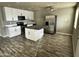 Modern kitchen featuring white cabinets, stainless appliances, island, and contemporary flooring at 14024 W Noble Cir, Casa Grande, AZ 85122