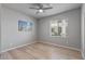 A simple bedroom featuring a ceiling fan, beach art and a window bringing in natural light at 14200 W Village Pkwy # 107, Litchfield Park, AZ 85340