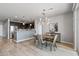 Elegant dining area with hardwood floors, a modern chandelier, a stylish credenza, and kitchen access at 14200 W Village Pkwy # 107, Litchfield Park, AZ 85340