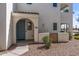 Charming front entrance with a light blue door, an arched entryway, and low maintenance desert landscaping at 14200 W Village Pkwy # 107, Litchfield Park, AZ 85340