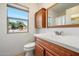 Bathroom showcases a wood vanity, a toilet, and a window offering natural light and views at 14215 N Boswell Blvd, Sun City, AZ 85351