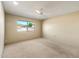 Comfortable bedroom with a ceiling fan, neutral carpet, and a bright window at 14215 N Boswell Blvd, Sun City, AZ 85351