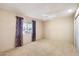 Comfortable bedroom includes neutral carpeting, a ceiling fan, and a window with outdoor views at 14215 N Boswell Blvd, Sun City, AZ 85351