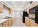 Well-lit kitchen with stainless steel appliances, light cabinetry, and a tile floor at 14215 N Boswell Blvd, Sun City, AZ 85351