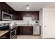 This kitchen features dark cabinets, stainless appliances, granite countertops, and a stylish backsplash at 14433 N 37Th St, Phoenix, AZ 85032