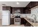 This kitchen has stainless appliances, granite countertops, dark cabinets, and lots of natural light at 14433 N 37Th St, Phoenix, AZ 85032