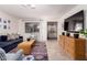 Bright living room featuring a large TV, wicker table, and neutral walls at 14433 N 37Th St, Phoenix, AZ 85032