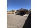 Spacious gravel backyard with covered patio and perimeter block fencing at 1606 S 226Th Dr, Buckeye, AZ 85326