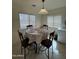 Light-filled dining area with a round table, seating for four, and modern lighting fixtures at 1606 S 226Th Dr, Buckeye, AZ 85326