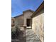 Beige home exterior with a desert landscape, and a walkway to a screened front door with a covered porch at 1606 S 226Th Dr, Buckeye, AZ 85326