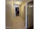 Hallway with tile floors leading to bedrooms and bathrooms with neutral paint and simple finishes at 1606 S 226Th Dr, Buckeye, AZ 85326