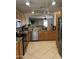 Kitchen view featuring granite countertops, wood cabinets, stainless steel appliances, and tile flooring at 1606 S 226Th Dr, Buckeye, AZ 85326