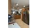 View of the kitchen, featuring wood cabinets, granite counters, stainless appliances, and tile floors at 1606 S 226Th Dr, Buckeye, AZ 85326