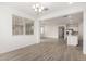 Open-concept living room with tiled floor, chandelier lighting and white kitchen in background at 16804 W Yucatan Dr, Surprise, AZ 85388