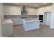 Modern kitchen with stainless steel appliances, white cabinets, and an island with a sink at 16954 W Molly Ln, Surprise, AZ 85387