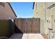 Exterior shot of a backyard gate with a metal frame and vertical wooden slats for privacy and security at 1765 N Agave St, Casa Grande, AZ 85122