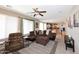 Inviting living room featuring a plush brown sectional and ceiling fan, seamlessly flowing into the open kitchen at 1765 N Agave St, Casa Grande, AZ 85122