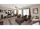 Bright living room with a brown sectional, large TV, and expansive windows for natural light at 1765 N Agave St, Casa Grande, AZ 85122