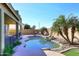 An in-ground swimming pool with a mature palm tree providing shade at 1765 N Agave St, Casa Grande, AZ 85122