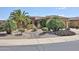 Attractive desert landscaping accents this tan home with a tile roof at 19437 N Guardian Ln, Surprise, AZ 85387