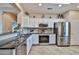 Well-lit kitchen featuring stainless steel appliances, granite counters, white cabinets, and a practical layout for cooking at 19437 N Guardian Ln, Surprise, AZ 85387