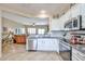 Modern kitchen with stainless steel appliances, granite countertops, white cabinets, and an open view to the living room at 19437 N Guardian Ln, Surprise, AZ 85387