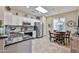 Bright kitchen featuring stainless steel appliances, white cabinetry, and a cozy dining nook with stylish lighting at 19437 N Guardian Ln, Surprise, AZ 85387