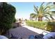 Covered brick patio with green landscape and palm trees at 19437 N Guardian Ln, Surprise, AZ 85387