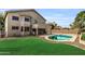 Backyard featuring refreshing pool, lush green grass, and covered patio with ceiling fans at 2015 S 80Th Ln, Phoenix, AZ 85043