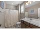 Well-lit bathroom featuring a toilet, shower with a white curtain, and a sink with a mirror at 20646 W Delaney Dr, Buckeye, AZ 85396