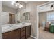 Bright bathroom with a double sink vanity and views of the main bedroom at 20646 W Delaney Dr, Buckeye, AZ 85396