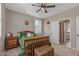 Comfortable bedroom with a wood bed frame, shutters, and a view into an ensuite bathroom at 20646 W Delaney Dr, Buckeye, AZ 85396