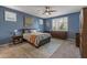 Serene blue bedroom featuring natural light, plantation shutters, and a ceiling fan at 20646 W Delaney Dr, Buckeye, AZ 85396