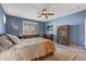 Comfortable bedroom featuring blue walls, ceiling fan and natural light from the window at 20646 W Delaney Dr, Buckeye, AZ 85396