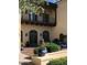 Elegant clubhouse entrance featuring arched doorways, a charming balcony, and beautiful landscaping at 20646 W Delaney Dr, Buckeye, AZ 85396