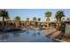 Stunning community pool featuring crystal-clear water, palm trees, and comfortable lounge chairs for residents to enjoy at 20646 W Delaney Dr, Buckeye, AZ 85396