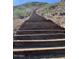 Hiking trail with wooden steps leading up a hillside, set in a natural desert landscape at 20646 W Delaney Dr, Buckeye, AZ 85396