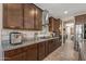 Modern kitchen with dark wood cabinets, stainless steel appliances, and sleek countertops at 20646 W Delaney Dr, Buckeye, AZ 85396