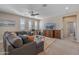 Relaxing living room with a gray sectional, lots of light, and entertainment center at 20646 W Delaney Dr, Buckeye, AZ 85396