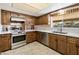 Traditional kitchen featuring wooden cabinetry, stainless steel appliances, and bright countertops at 2205 E Fox St, Mesa, AZ 85213