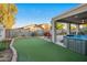 Inviting backyard with a putting green, hot tub, covered patio, and desert landscaping at 28249 N Shundeen Cir, San Tan Valley, AZ 85143